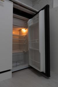 an empty refrigerator with its door open in a room at Евродвушка в ЖК Тениз in Kostanay