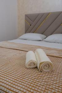 two towels are laying on a bed at Евродвушка в ЖК Тениз in Kostanay