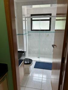 a bathroom with a shower with a toilet and a window at Piemonte Flat Hotel in Serra Negra