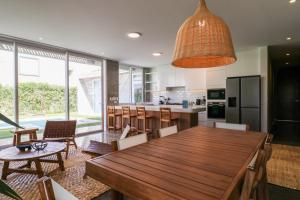 una cocina con una gran mesa de madera y sillas en Modern 4BR Villa with Private Pool in Paracas en Paracas