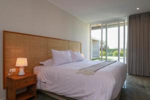Un dormitorio con una gran cama blanca y una ventana en Modern 4BR Villa with Private Pool in Paracas en Paracas
