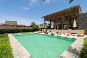 una piscina con sillas y una casa en Modern 4BR Villa with Private Pool in Paracas en Paracas
