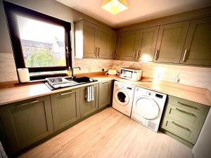 a kitchen with a washing machine and a window at Grampian Serviced Apartments - Ladyhill Neuk - 1 Bedroom Apartment in Elgin