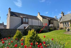 a house with a red arrow in front of it at Grampian Serviced Apartments - Ladyhill Neuk - 1 Bedroom Apartment in Elgin