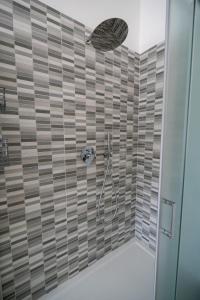 a bathroom with a shower with brown tile at Luna apartment in Aci Castello +9 photos