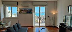 uma sala de estar com um sofá, uma mesa e janelas em Faro exclusive suite em Bari