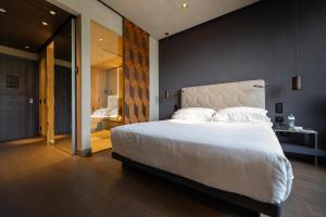 a bedroom with a large white bed and a bathroom at Hotel VIU Milan, a Member of Design Hotels in Milan