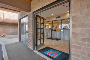 - un bâtiment en briques avec des portes coulissantes en verre et des tapis de yoga au sol dans l'établissement Motel 6 Willcox, AZ, à Willcox