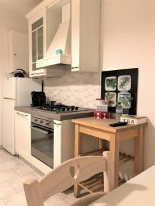 una cucina con piano cottura e tavolo in legno di Comfortable Apartment in Sant'Orsola a Bologna