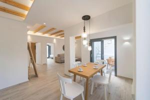 a dining room and living room with a table and chairs at Nostos Apartments Fira in Fira