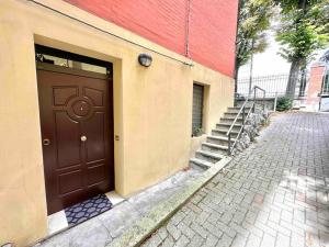 una porta marrone sul lato di un edificio con scale di Comfortable Apartment in Sant'Orsola a Bologna