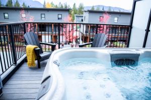 einen Whirlpool auf der Terrasse eines Hauses in der Unterkunft Powder & Pines - Cozy 2 Bedroom with Hot Tub in Revelstoke