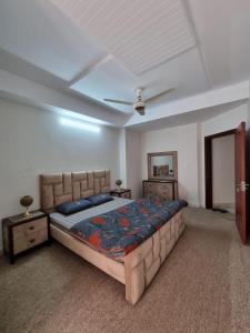 a bedroom with a large bed and a ceiling at Three Bed Attached Bath Netflix Wifi Smart TV Parking Near Airport in Islamabad