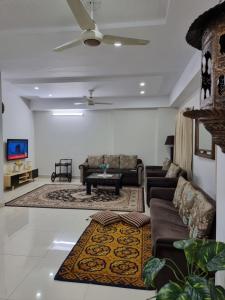 a living room with couches and a ceiling fan at Three Bed Attached Bath Netflix Wifi Smart TV Parking Near Airport in Islamabad