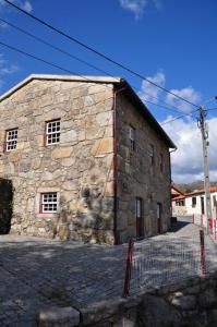 a large stone building with windows on the side of it at Casa do Postigo in Geres