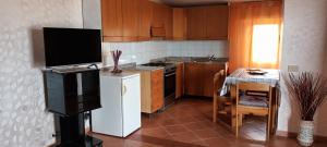 a small kitchen with a white refrigerator and a television at Giusi's House in Cava dʼAliga