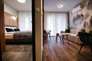 een woonkamer met een bed en een bank bij Laguna Beskidów Forest 22 & 23 in Zarzecze