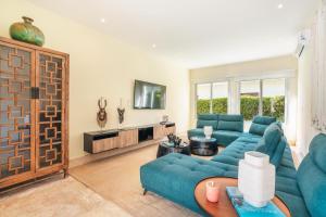un soggiorno con divano blu e TV di New listing! Heavenly villa at Hacienda a Punta Cana
