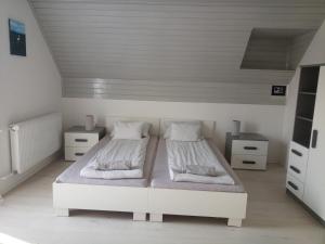 1 dormitorio blanco con 2 camas y 2 mesitas de noche en Tiszavirág Vendégház, en Poroszló