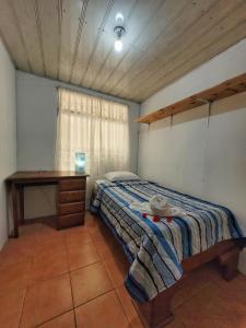 Un dormitorio con una cama y una mesa. en Monteverde River House, en Monteverde