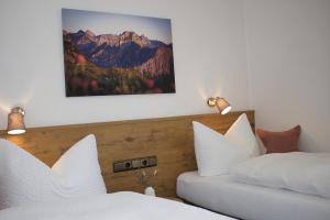 a bedroom with two beds with white pillows at Gästehaus Alpenruh in Fischen