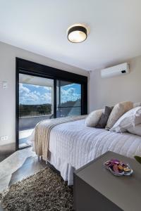 - une chambre avec un lit et une grande fenêtre dans l'établissement Vale do Purunã Flats de Lazer, à Balsa Nova