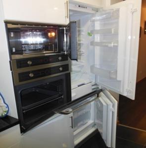 an open refrigerator with an open oven in it at Residence Palmeira II in Beira