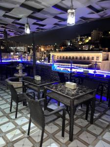 a restaurant with tables and chairs with a view of a city at Downtown Hawaa Amman Hotel in Amman