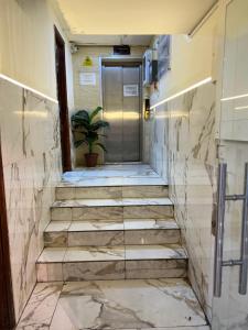 un corridoio con scale e una porta con una pianta in vaso di Downtown Hawaa Amman Hotel ad Amman