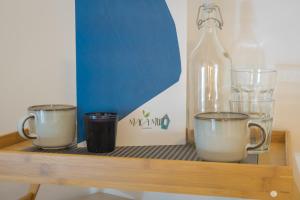 a shelf with two cups and a bottle of wine at Maga Mirò - Guest House in Salerno