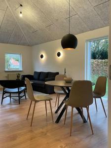 uma sala de estar com uma mesa e cadeiras e um sofá em Hyggelig nyrenoveret lejlighed til 4 Personer em Agerbæk