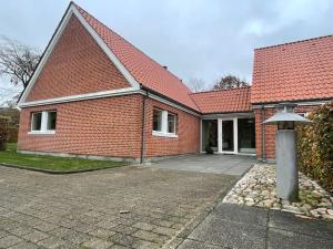 ceglany dom z czerwonym dachem w obiekcie Hyggelig nyrenoveret lejlighed til 4 Personer w mieście Agerbæk