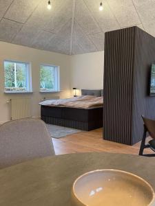 ein Schlafzimmer mit einem Bett in der Mitte eines Zimmers in der Unterkunft Hyggelig nyrenoveret lejlighed til 4 Personer in Agerbæk
