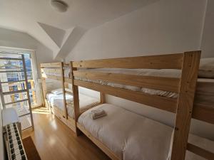 2 Etagenbetten in einem Zimmer mit Fenster in der Unterkunft IMEDA Apartamentos BUENAVISTA LODGE in Sierra Nevada