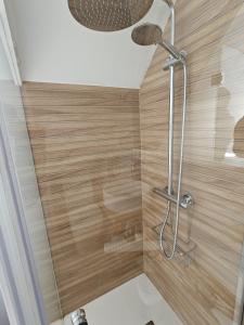 y baño con ducha y paredes de madera. en IMEDA Apartamentos BUENAVISTA LODGE en Sierra Nevada