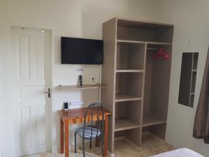 a room with a desk with a tv and shelves at VilaVerin Apartments in Manaus