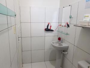 a white bathroom with a sink and a mirror at VilaVerin Apartments in Manaus