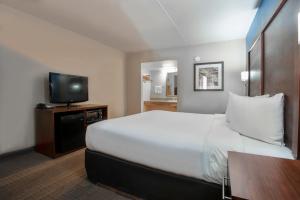 a hotel room with a bed and a flat screen tv at Suites Willcox AZ in Willcox