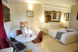 a hotel room with two beds and a table with flowers at B&B GianLuis in Fasano