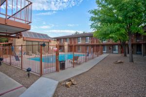 a fence with a pool in front of a building at Suites Willcox AZ in Willcox