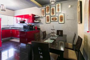 una cocina con armarios rojos y una mesa con sillas. en Gueliz Gala – Marrakech Centre, en Marrakech