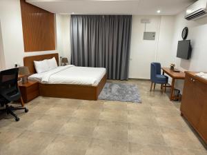a hotel room with a bed and a desk and chair at Express City Hotel - Duqm in Duqm