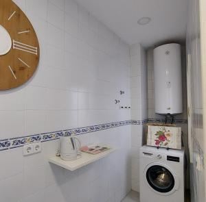 a laundry room with a washing machine and a clock at Magdalena Plaza City Center 2 in Seville +33 photos