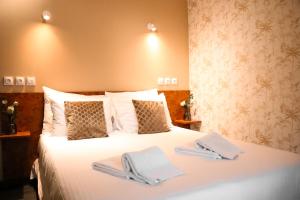 a bedroom with a white bed with towels on it at Maria Grazia Hotel in Saint Gatien des Bois