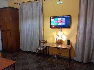 una camera con tavolo e TV a parete di B&B Donna Elvira a Siderno Marina