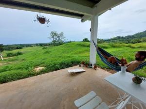 a man laying in a hammock on a porch at Paradise Venao - Cañas in Cañas