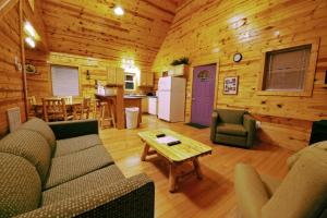 a living room with a couch and a table at The Cabins at Pine Haven - Beckley in Beaver