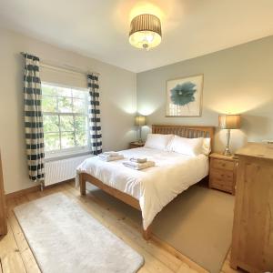 a bedroom with a bed and a window at Green Cottages in Sittingbourne