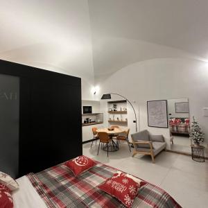 a bedroom with a bed and a dining room at Dislocati BnB - Jacuzzi privata - Cucina - TV60" - Minimal Luxury in Marigliano