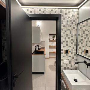 a small kitchen with a sink and a counter at Dislocati BnB - Jacuzzi privata - Cucina - TV60" - Minimal Luxury in Marigliano +64 photos